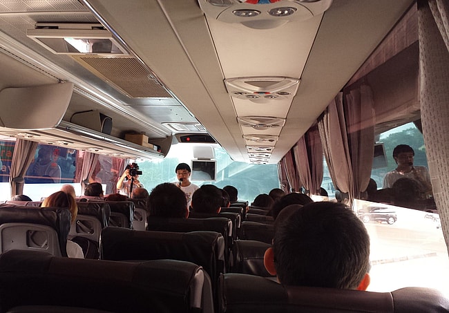 Lim Jialiang tries to fire up the Love Bus riders on the way to Johor. Photograph by Kelly Leow.